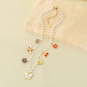 Macro detail of multi-pendant pearl necklace with stainless steel engraving and bee charms