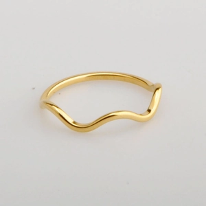 Close-up of minimalist wave-shaped gold ring with smooth polished metallic finish