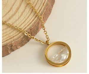 Close-up of a gold 18K stainless steel necklace with a clear crystal heart pendant