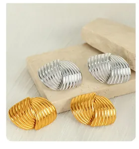 Macro shot of titanium steel earrings with striped texture in gold and silver finish