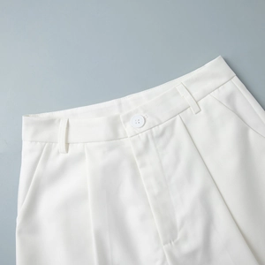 Detailed close-up of white vest suit trousers waist featuring button and zipper fly