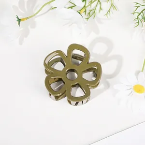 Detailed close-up of dark green flower hair claw clip with white daisies on background