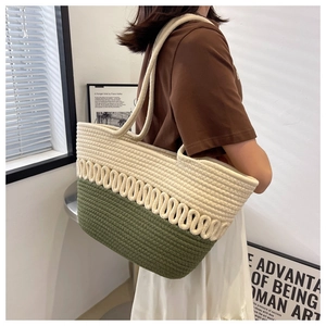 Close-up of olive green and beige woven tote bag with wavy texture and cotton rope detail
