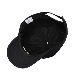 Inside view of black cotton baseball cap showing internal stitching and wash care label