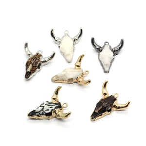 Macro shot of assorted resin bull skull pendants with metallic horns and stone details