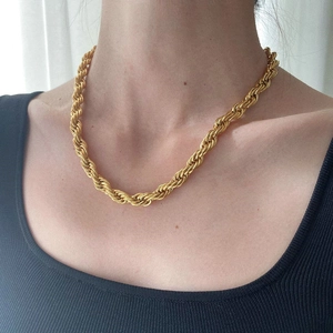 Gold twist rope chain necklace in stainless steel worn by a model for fashion look