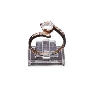 Anello in oro rosa con grande diamante rotondo su espositore in acrilico trasparente