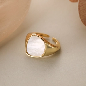 Detailed macro view of gold-plated heart ring with triangle shell inlay and adjustable band