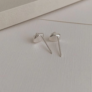 Macro view of minimalist S925 sterling silver stud earrings with zircon on textured paper