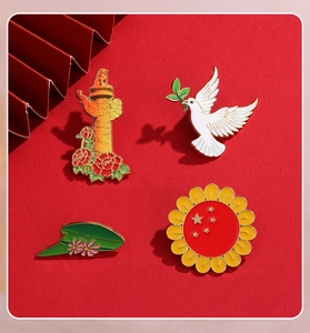 Détail de quatre broches en émail aux motifs de colombe et fleur sur fond rouge