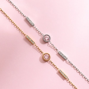 Detail of 18K gold and silver steel bracelets with pink zircon and baguette diamonds