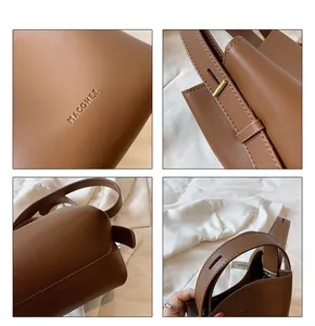Detail of brown leather bucket bag showing fine stitching and gold metal hardware