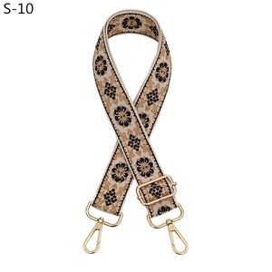 Close-up of bohemian floral woven bag strap with golden adjustable metal buckles