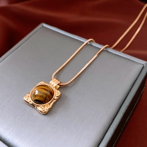 Dettaglio della collana con pendente in pietra occhio di tigre placcata oro 18K su astuccio