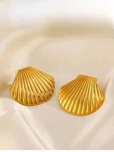Vue macro détaillée de boucles d'oreilles coquillage dorées 18 carats sur soie