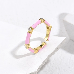 Macro detail of gold-plated bamboo ring with pink enamel and sparkling zircon accents