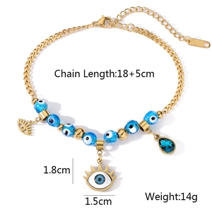 Dettaglio del bracciale dorato con perline, ciondoli malocchio e cristallo blu