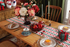 Detail of cotton Christmas table runner with red and green tassel stripe patterns