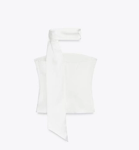 Detail of white satin halter top featuring a long neck scarf and silky texture
