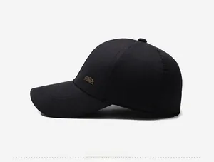 Detail view of the black baseball cap featuring a bronze mountain metal logo on the side