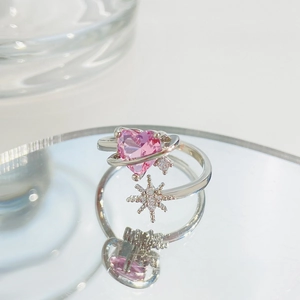 Close-up of silver ring featuring a pink heart stone and micro-set star detail on mirror
