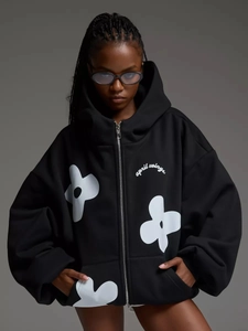 Detailed close-up of thick knit cotton hoodie with white floral print and zip-up design