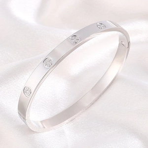 Detailed macro of silver stainless steel bangle with sunburst engraving on silk