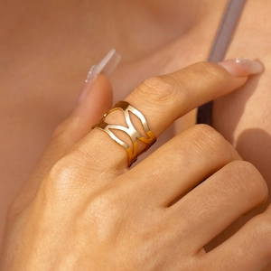 Gros plan détaillé d'une bague géométrique dorée ajourée avec finition en métal poli