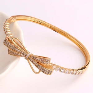 Detail of gold plated bow bracelet featuring shimmering micro-paved cubic zirconia