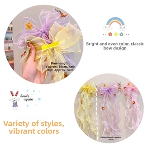Detail of floral organza bow hair clip with colorful long ribbons for girls