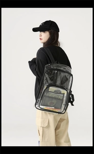 Detail view of large transparent PVC backpack worn by model showing interior storage