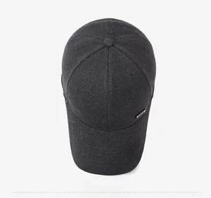 Vue de dessus d'une casquette gris foncé avec texture laine et logo métallique latéral