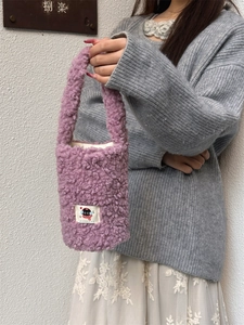 Detail of purple plush water bottle carrier featuring a cute black cat embroidered patch