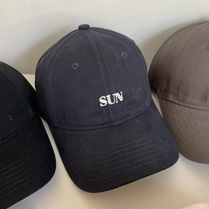 Close-up of cotton baseball caps in black, navy, and brown with SUN embroidery