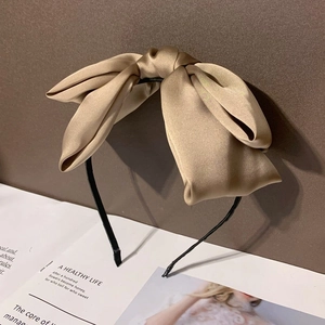 Gros plan détaillé d'un serre-tête en satin champagne avec une texture de tissu plissé