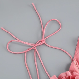 Gros plan d'une robe rose sexy montrant la fermeture éclair et les détails volantés