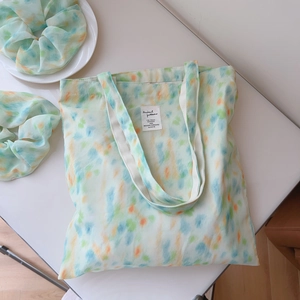 Detail of mint green watercolor chiffon tote bag with matching scrunchie and label
