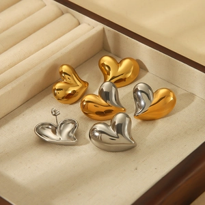 Polished 18k stainless steel heart stud earrings in gold and silver finish in a jewelry box