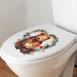 Close-up of Christmas bear wreath sticker on a white toilet lid for festive home decor