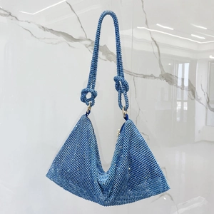 Detail of blue rhinestone shoulder bag featuring knotted strap and glittering crystals