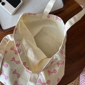 Détail du sac en coton avec motifs de nœuds roses et poche intérieure de rangement