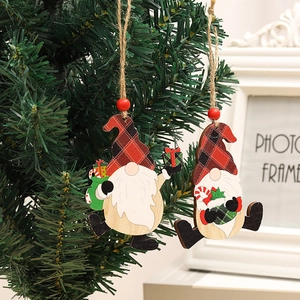 Detail von hölzernen Wichtel-Anhängern mit Karomuster an einem Weihnachtsbaum-Zweig