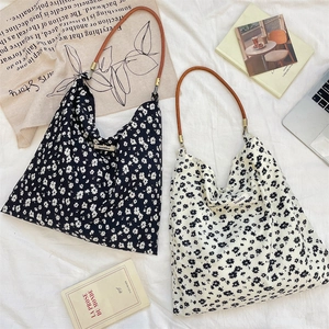 Vue détaillée de sacs cabas en toile à fleurs avec imprimés marguerites et cuir