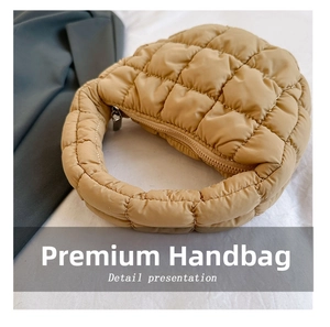 Detail view of khaki quilted puffer cloud bag with integrated handle and metal zipper