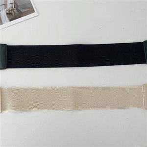 Detail view of elastic waist belts in black and beige showing woven texture and stretch