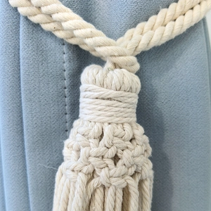 Minimalist hand-woven cotton rope curtain tieback with decorative tassel in cream beige