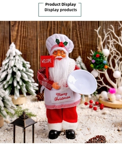 Detail of chef Santa Claus figurine holding a Welcome sign with festive pine decorations