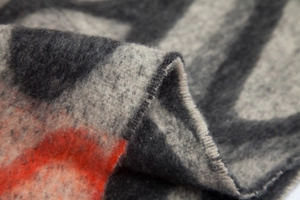 Macro detail of thick faux mohair shawl with wave patterns and soft orange textured fibers