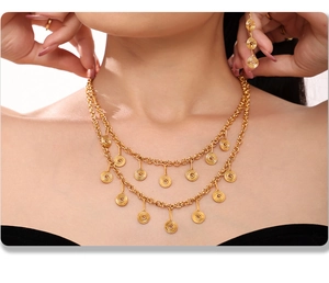 Elegant gold double-layered necklace and spiral earrings set worn by model on black top