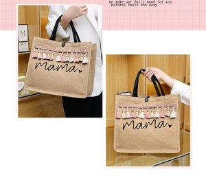 Detail of linen tote bag with mama print, colorful tassels, and black handles
